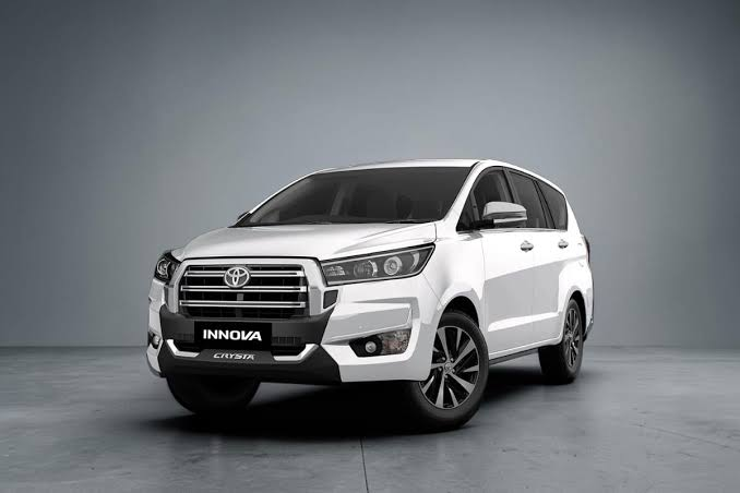 White Toyota Innova SUV taxi parked in front of Himalayan mountains - Vishal taxi services fleet
